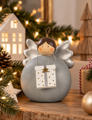 Decoro angelo in ceramica grigia con pacco regalo in metallo e ali argentate ambientato 